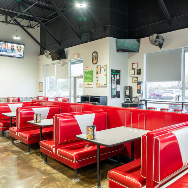 Interior of Grampie's Pizzeria with rows of red and white diner-style booths and tables.