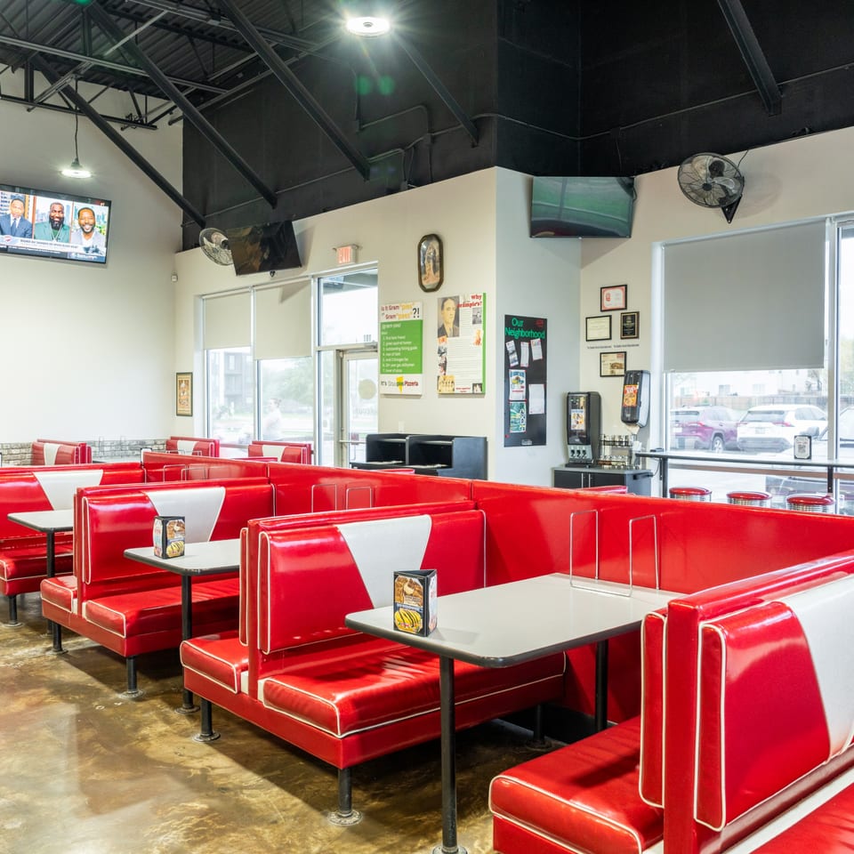 Interior of Grampie's Pizzeria with rows of red and white diner-style booths and tables.